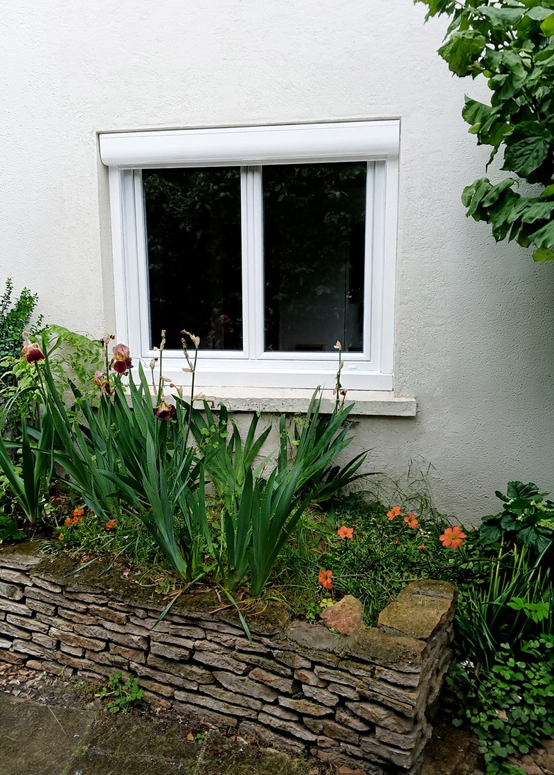Fenêtre blanche en PVC de la gamme INO'80 avec décoration extérieure végétale